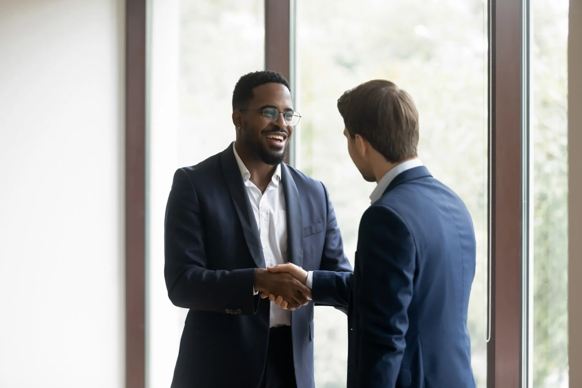 Overjoyed multiethnic businessmen shake hands